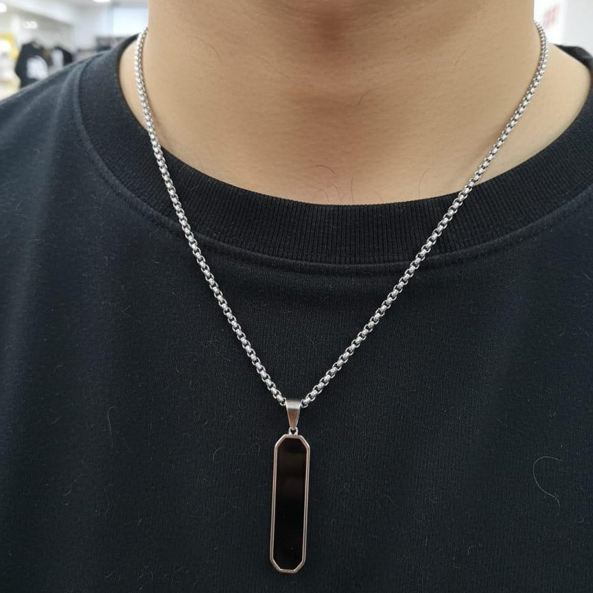 Person wearing a black pendant necklace